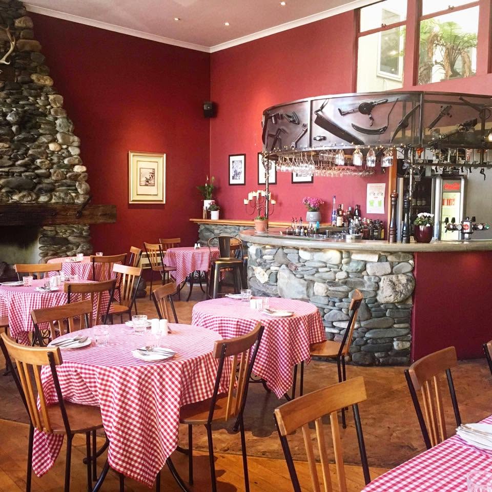 Burgundy walls, river stone fireplace and bar, gingham tables