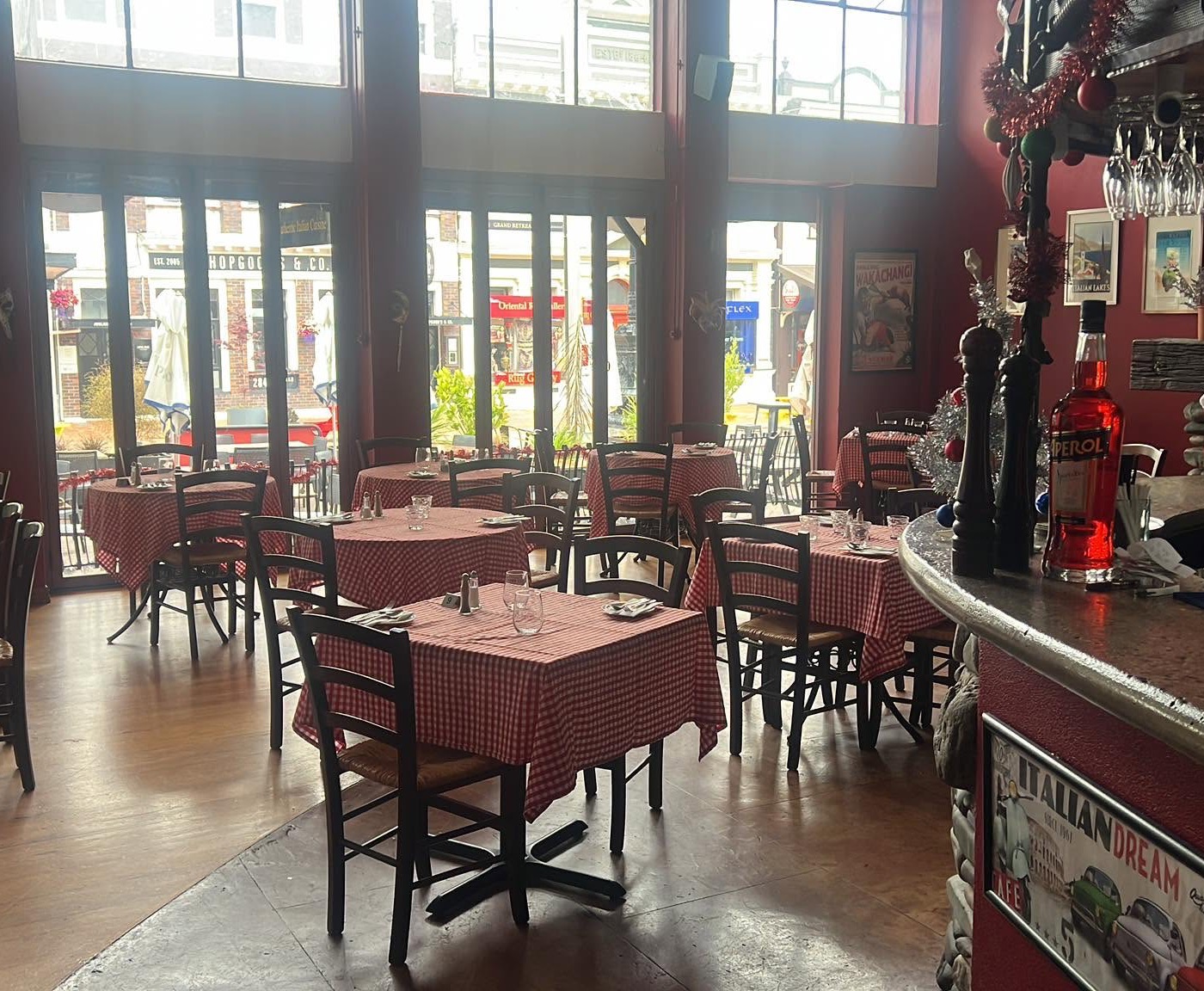 The dining room at Lombardi's, gingham tables in front of tall windows onto Trafalgar Street