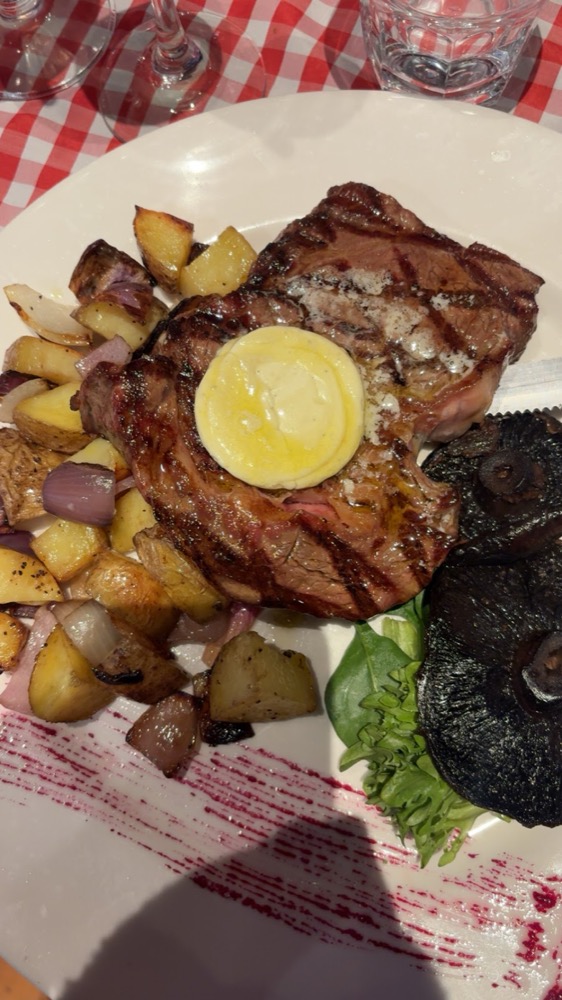 Ribeye with herb butter, roast potatoes and portobello mushroom