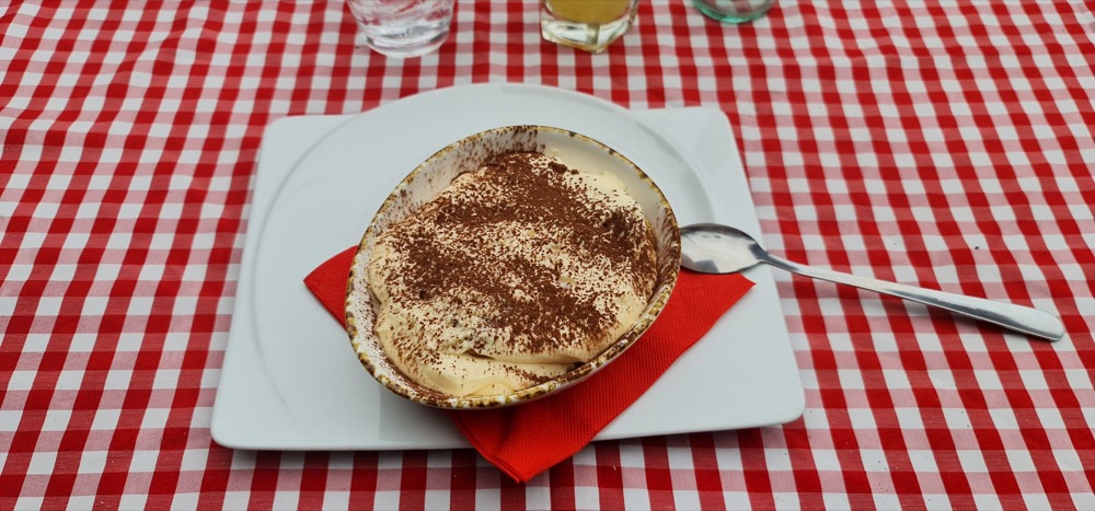 Tiramisu dusted with cocoa on a gingham tablecloth